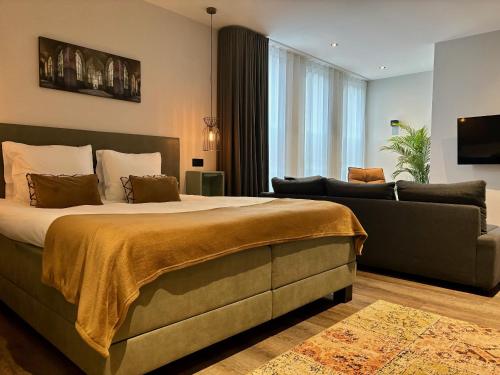 sypialnia z dużym łóżkiem i kanapą w obiekcie Hotel La Boutique w mieście Nijmegen