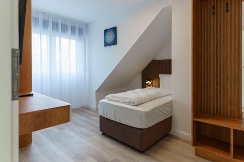 a small bedroom with a bed and a staircase at Haus der Sonne in Soltau