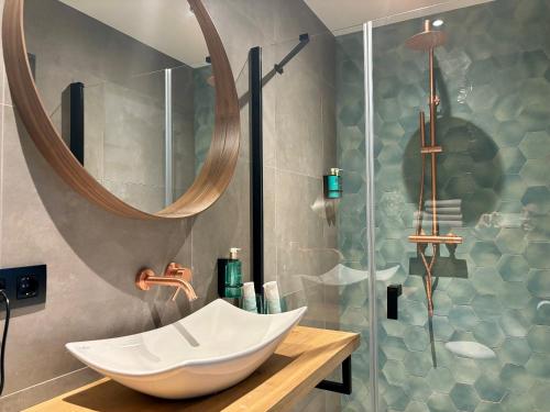 een badkamer met een wastafel en een douche met een spiegel bij Hotel La Boutique in Nijmegen