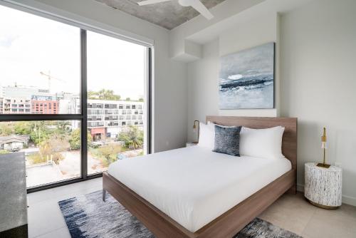 a bedroom with a bed and a large window at Kasa Wynwood Miami in Miami