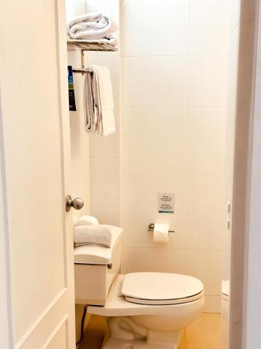 a small bathroom with a toilet and towels at El Golf Hotel Boutique in Lima
