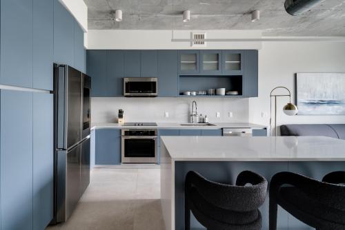 a kitchen with blue cabinets and a white counter top at Kasa Wynwood Miami in Miami