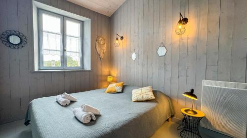ein Schlafzimmer mit einem Bett mit Handtüchern darauf in der Unterkunft Charmante maison de village in Le Bois-Plage-en-Ré