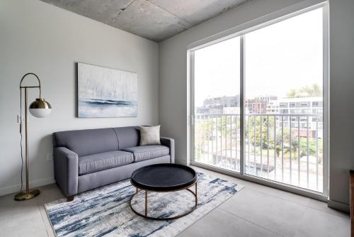 a living room with a couch and a large window at Kasa Wynwood Miami in Miami