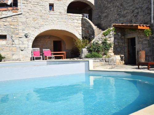 a swimming pool in front of a stone building at Vintage Holiday Home in Lanas with Swimming Pool in Lanas