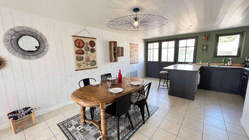 une cuisine et une salle à manger avec une table et des chaises en bois dans l'établissement Charmante maison de village, au Bois-Plage-en-Ré
