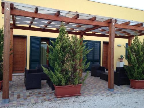 a patio with potted plants and a wooden pergola at Agriturismo Mele in Copertino