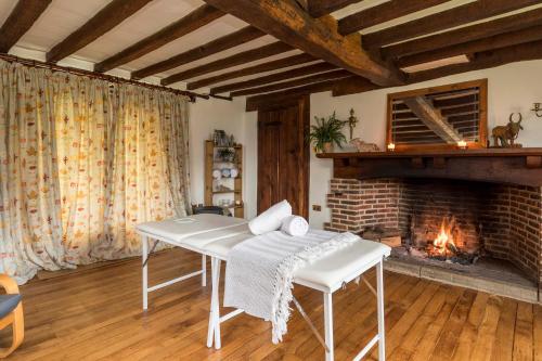 a living room with a table and a fireplace at Beautiful Yurt with stunning South Downs views in Graffham