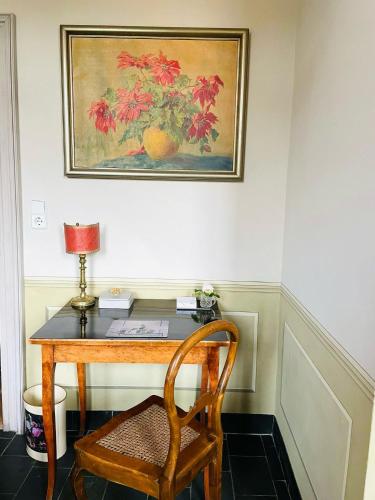 a desk with a chair and a picture of an orange at Gästehaus Schönitz in Meißen