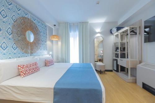 1 dormitorio con 1 cama grande y pared azul en Soho Boutique Cádiz, en Cádiz