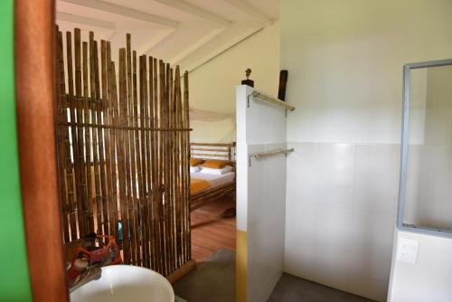 a bathroom with a door to a room with a bed at Finca cafetera El Abanico Lodge in Pereira