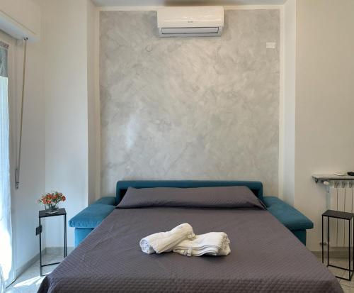 une chambre avec un lit avec une tête de lit bleue dans l'établissement La Papera Sciocca, à La Spezia