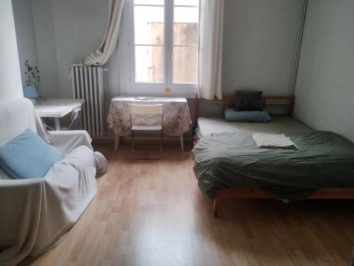 um quarto com duas camas e uma mesa e uma janela em Cozy Roomy em Montpellier