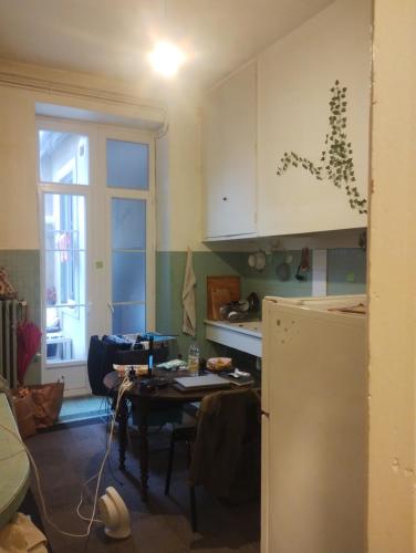 eine Küche mit einem Tisch und einem Kühlschrank in der Unterkunft Cozy Roomy in Montpellier