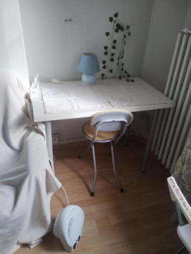 uma mesa branca com uma cadeira num quarto em Cozy Roomy em Montpellier
