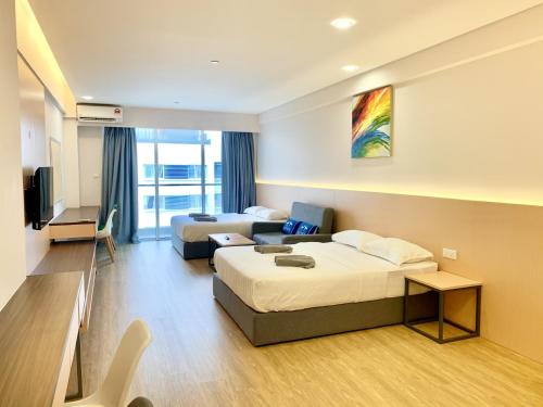 a hotel room with two beds and a couch at Deco Home @ Aru Suites in Kota Kinabalu