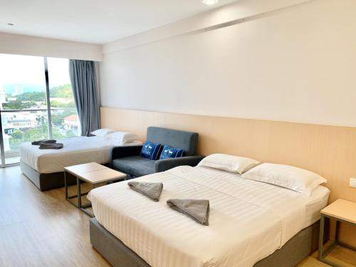 a hotel room with two beds and a couch at Deco Home @ Aru Suites in Kota Kinabalu
