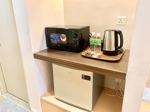 a room with a counter with a microwave and a toaster at Deco Home @ Aru Suites in Kota Kinabalu