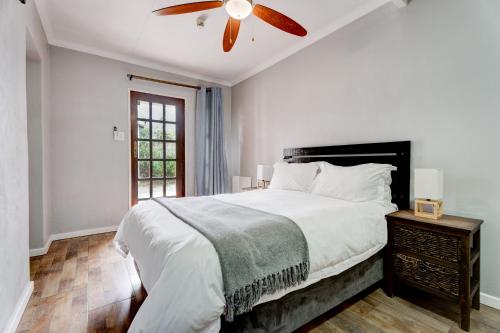 1 dormitorio con 1 cama y ventilador de techo en The Bosau Guest House en Pretoria