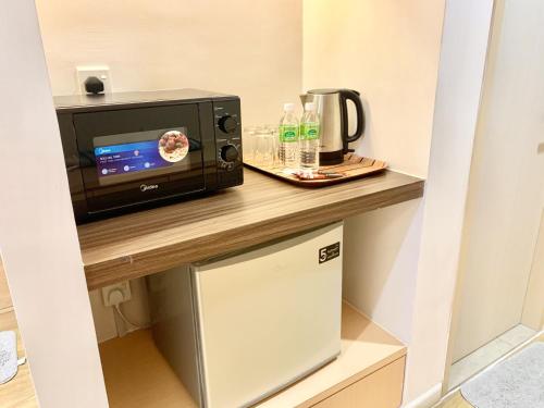 a microwave oven sitting on a counter in a room at Deco Home @ Aru Suites in Kota Kinabalu