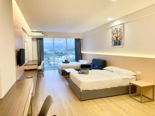 a hotel room with two beds and a flat screen tv at Deco Home @ Aru Suites in Kota Kinabalu