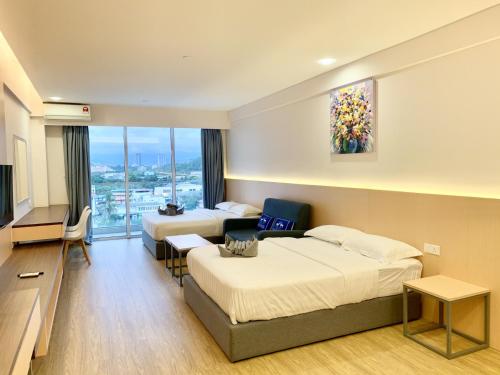 a hotel room with two beds and a television at Deco Home @ Aru Suites in Kota Kinabalu