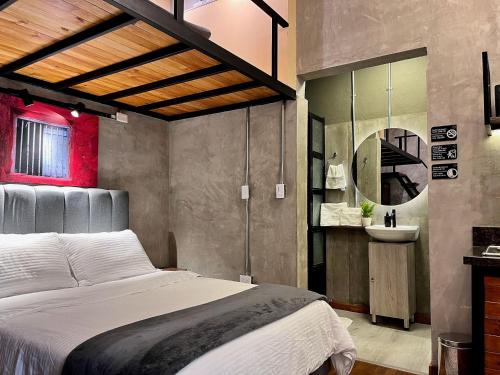 1 dormitorio con 1 cama grande y lavamanos en 211 Aparta Studio Boutique en mansión siglo XIX, en Bogotá