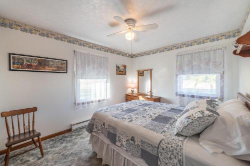 Schlafzimmer mit einem Bett und einem Deckenventilator in der Unterkunft Sunset Cottage 