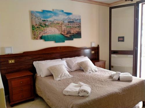 a bedroom with a large bed with towels on it at Hotel Grotticelli in Scopello