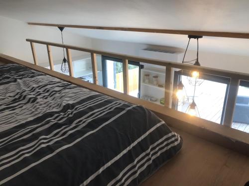 een slaapkamer met een bed en een groot raam bij Studio au calme, grande terrasse avec vue vallée in Ginasservis