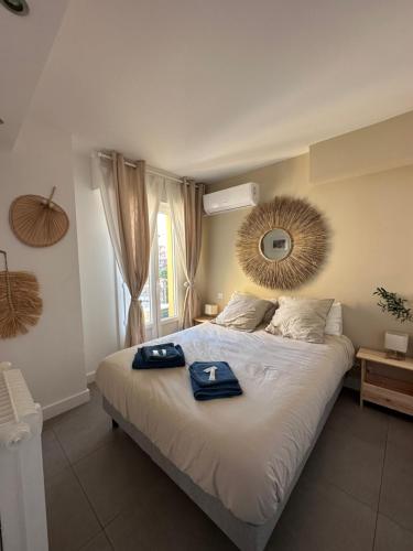 une chambre avec un lit avec deux serviettes bleues dessus dans l'établissement Antibes, tout à vos pieds, à Antibes