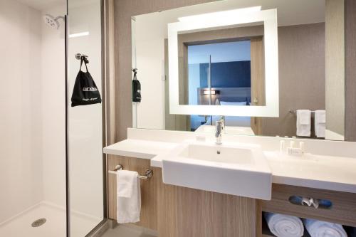 a bathroom with a sink and a mirror at SpringHill Suites by Marriott Hampton Portsmouth in Hampton