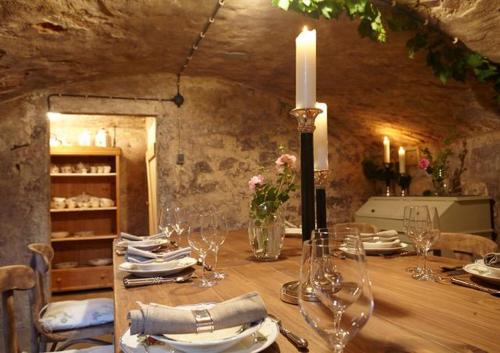 a table with a candle and plates and wine glasses at Gästehaus Schönitz in Meißen