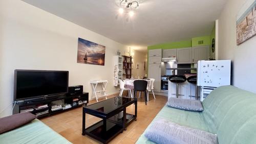 un salon avec un canapé et une télévision à écran plat dans l'établissement Appartement pour 4 personnes proche mer, au Crotoy