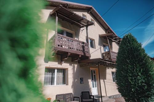 a building with a balcony and chairs on it at Alpine Bliss Sinaia in Sinaia