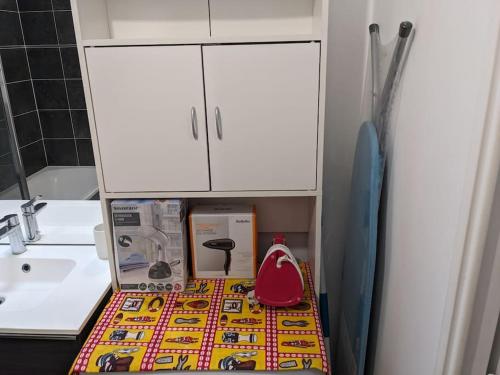 - une cuisine avec un évier et des placards blancs dans l'établissement Logement chaleureux aux portes de Paris, à Noisy-le-Sec