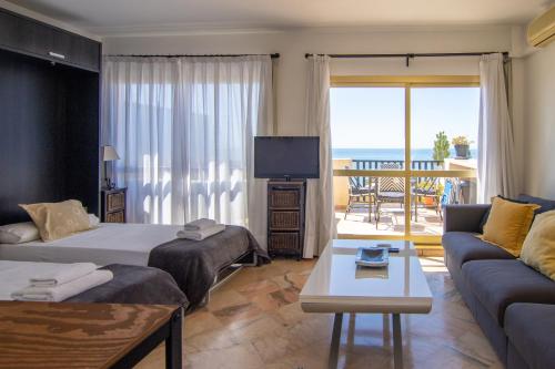 ein Wohnzimmer mit 2 Betten und einem Sofa in der Unterkunft OleHolidays 655 Romana Playa vistas al mar in Marbella