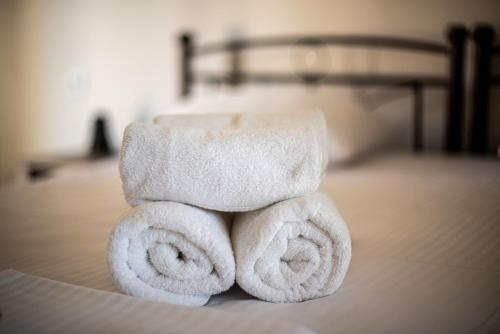 uma pilha de toalhas sentadas em cima de uma cama em Elia Apartments em Agia Marina Aegina