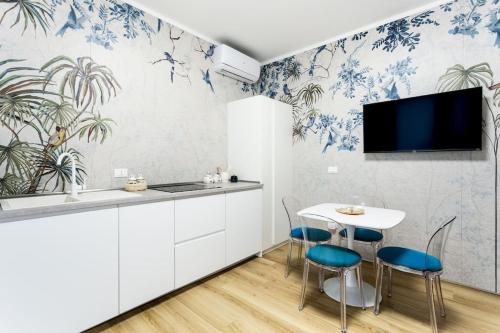 a kitchen with blue and white wallpaper and a table and chairs at La Bella Vita - Wonderland in Sottomarina