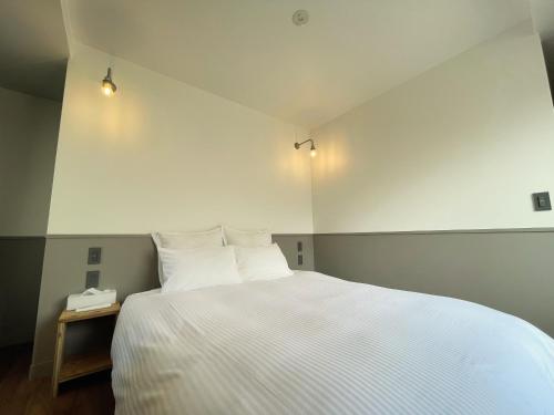 a bedroom with a large white bed with two pillows at Hotel Yuzuki in Takamatsu