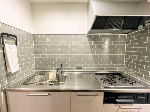 a kitchen with a sink and a stove at Hotel Yuzuki in Takamatsu