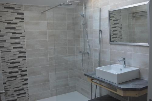 y baño con lavabo y ducha. en Gîte de LANVIAN en Guissény
