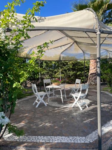 patio con tavolo e sedie sotto ombrellone di Casa Encanto Latribu a Rodeo de la Cruz