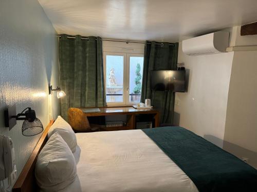 a bedroom with a bed and a desk and a window at Hôtel Du Leman in Paris