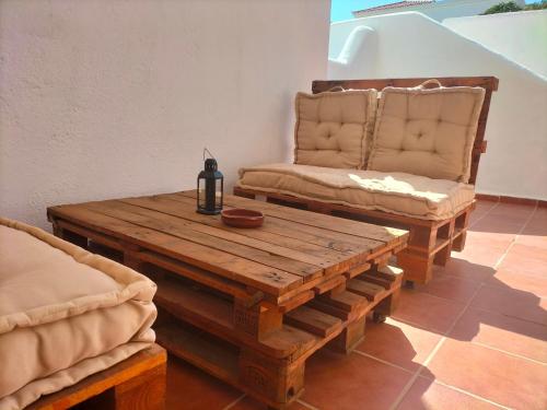 a living room with a wooden table and a chair at Port Royale Los Cristianos in Los Cristianos