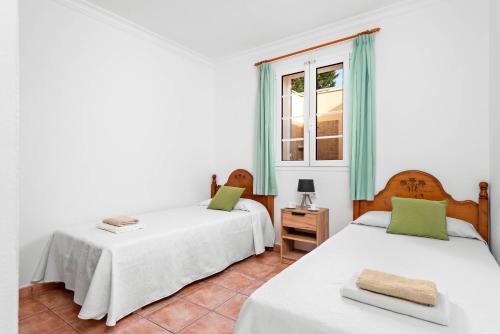 una camera con due letti e una finestra di Villa Sol Menorca a Punta Prima