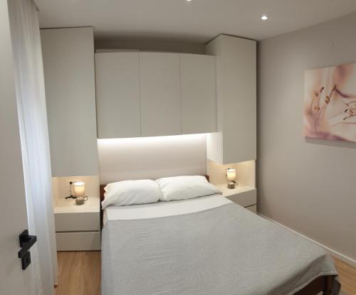 a bedroom with a bed and two lights on the wall at Apartment Bagaric in Stari Grad