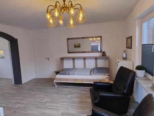 ein Schlafzimmer mit einem Bett, einem Sofa und einem Kronleuchter in der Unterkunft LaPurka III Garten in Nordhorn