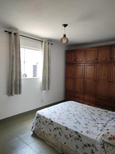 a bedroom with a bed and a window at Casa para Temporada in Resende