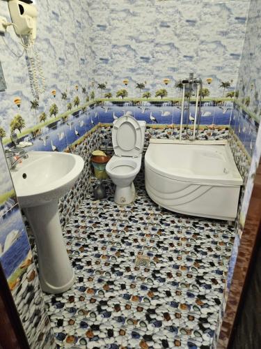 een badkamer met een toilet, een bad en een wastafel bij B&B Bahodir in Samarkand